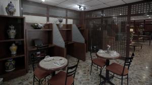 um restaurante com duas mesas e cadeiras num quarto em Hotel El Greco em Cidade do México