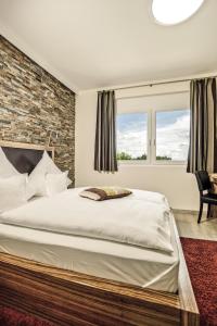 a bedroom with a large bed and a brick wall at Hotel Maxis in Karlsbad