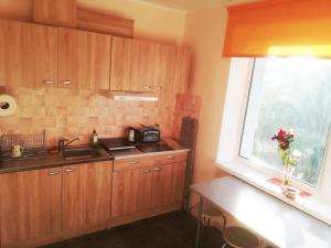 a kitchen with wooden cabinets and a sink and a window at Couple getaway to a freshly renovated apartment in Pärnu