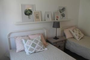 a bedroom with two beds and a shelf with pictures at Charming baixa in Lavradio
