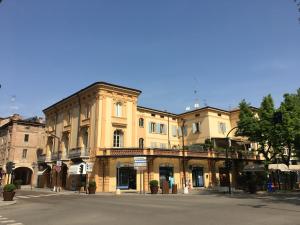 een groot geel gebouw met een balkon in een straat bij Domus Aurea in Carpi