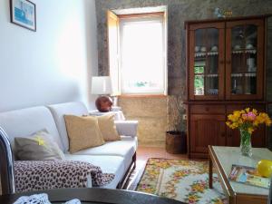 ein Wohnzimmer mit einem weißen Sofa und einem Fenster in der Unterkunft Casa do Pinheiro Manso in Valença