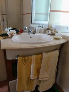 a bathroom with a sink with towels hanging from it at Casa do Pinheiro Manso in Valença