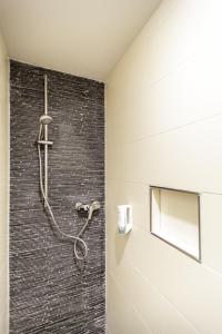 eine Dusche im Bad mit Ziegelwand in der Unterkunft Hotel Maxis in Karlsbad