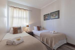 um quarto com duas camas com toalhas em York Mews 14 by CTHA em Cidade do Cabo
