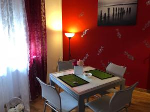 サレルノにあるCorso 126 Guest House Salernoの赤い壁のダイニングルーム(テーブル、椅子付)