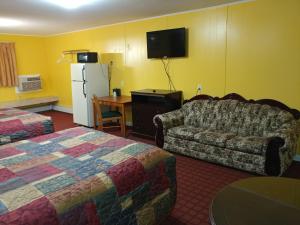 a hotel room with a bed and a couch and a tv at Maine Motel in South Portland