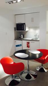 a kitchen with a black table and two red chairs at Apartamento Punta Carretas in Montevideo