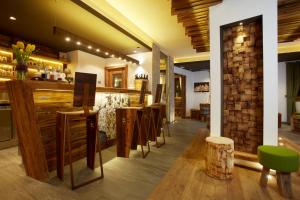 a restaurant with a bar with a bunch of chairs at Chalet Vites Mountain Hotel in Canazei