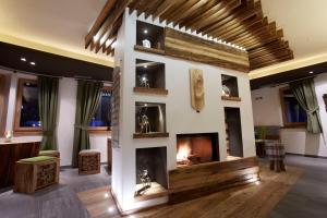 a living room with a fireplace in the middle at Chalet Vites Mountain Hotel in Canazei