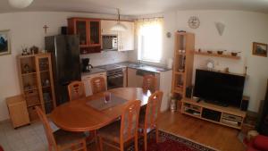 a kitchen with a dining room table and a television at Apartments Iva und Franka in Omiš