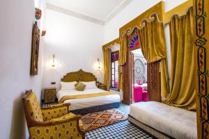 a bedroom with a bed and two chairs in it at Dar Bab Guissa in Fès