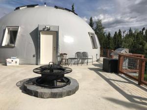 a dome house with a fire pit on a patio at Delta Dome Home Basement Apartment in Delta Junction