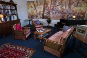 uma sala de estar com cadeiras, um sofá e um piano em Northern Arts Hotel em Castlemaine