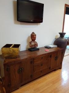 a wooden cabinet with a television on top of it at Tantarra Bed & Breakfast in Warners Bay