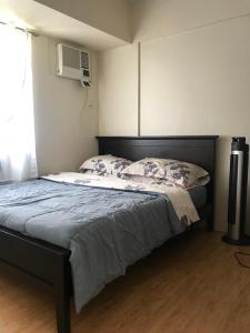 une chambre avec un lit, une télévision et une fenêtre dans l'établissement Cozy 922 at Tower One, à Cebu 10 autres photos