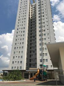 un grand bâtiment blanc avec une aire de jeux devant dans l'établissement Cozy 922 at Tower One, à Cebu