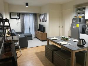a small living room with a table and a kitchen at Cozy 922 at Tower One in Cebu City