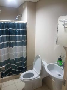 une salle de bain avec toilettes et lavabo dans l'établissement Cozy 922 at Tower One, à Cebu