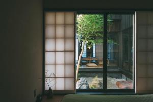 una camera con finestra affacciata su un giardino di Wuz Kamogawa a Kyoto