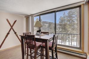 jadalnia ze stołem i krzesłami oraz dużym oknem w obiekcie 2065 The Pines Condo w mieście Keystone