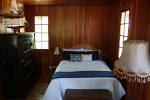 a bedroom with a bed with wooden walls and windows at Aaron's on the Lake in Matlock