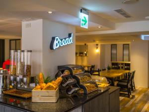 eine Bäckerei mit Brot und anderen Speisen auf der Theke in der Unterkunft Watermark Hotel - Sizihwan in Kaohsiung