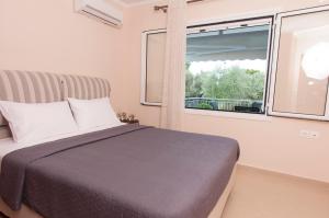 a bedroom with a bed and a window at A perfect summer destination next to the sea in Mikrá Mandínia