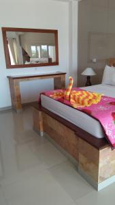 a bedroom with a bed with a wooden frame and a mirror at Ocean Resort Amed in Amed