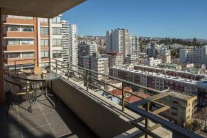 a balcony with a table and a view of a city at Departamento Viña Del Mar 4 Norte in Viña del Mar