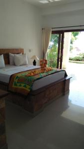 1 cama grande en un dormitorio con ventana en Ocean Resort Amed, en Amed