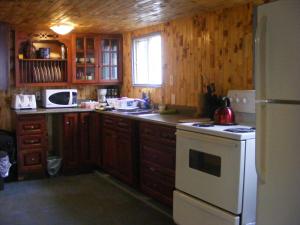 a kitchen with wooden cabinets and a white stove top oven at 78 Montague in Digby