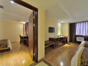 a hotel room with a bedroom with a desk and a desk at Greentree Alliance Beijing West Railway Station Zhanqian North Square Hotel in Beijing