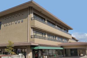 a large building with a balcony on the side of it at Hotel Binario Saga Arashiyama in Kyoto