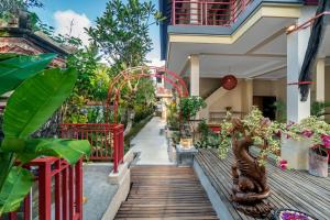 a house with a wooden walkway with plants at Metteyya Healing House in Ubud