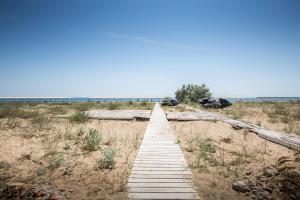 a wooden boardwalk in the middle of a beach at Gold Bugaz Apartment near the sea in Karolino-Buhaz