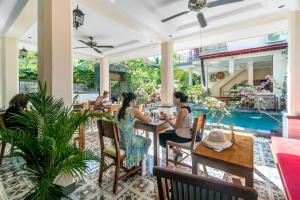 un groupe de personnes assises à une table dans un restaurant dans l'établissement Metteyya Healing House, à Ubud