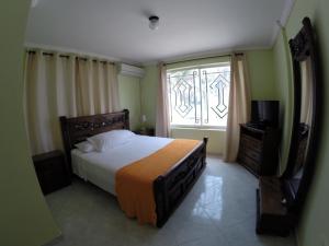 a bedroom with a bed and a window and a television at Zippy´s Sea View Apartments in San Andrés