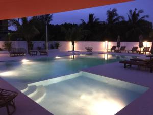 a swimming pool at night with chairs and lights at Sunset Lounge in Sihanoukville