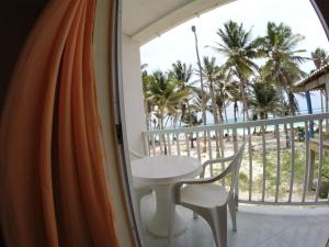 a balcony with a table and chairs and palm trees at Zippy´s Sea View Apartments in San Andrés
