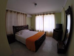 a bedroom with a bed and a television in it at Zippy´s Sea View Apartments in San Andrés