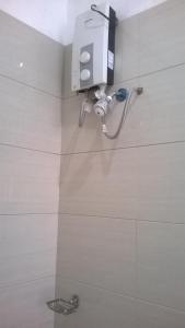 a shower in a bathroom with a soap dispenser on the wall at Meaco Hotel - Anilao in Mabini