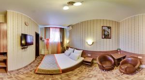 Habitación de hotel con cama, mesa y sillas en Zvezda Guest House, en Saratov