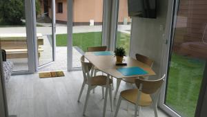 - une table et des chaises dans une chambre avec fenêtre dans l'établissement Ośrodek Wrzos, à Boruja