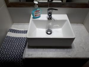 a bathroom sink with a bottle of detergent on it at Margarita Studios in Parikia