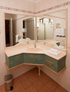 a bathroom with a sink and a large mirror at James Street Motor Inn in Toowoomba