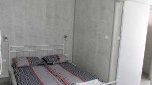 małe łóżko z 2 poduszkami i lustrem w obiekcie Ośrodek Wrzos w mieście Boruja