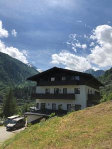 a building on a hill with a car parked in front at Apartment SHEPS in Kaprun in Kaprun