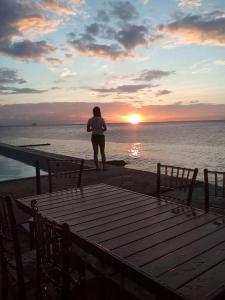 a person standing on the beach watching the sunset at Meaco Hotel - Anilao in Mabini