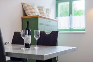 - une bouteille de vin assise sur une table avec deux verres dans l'établissement Slovanský penzion, à Mikulčice
